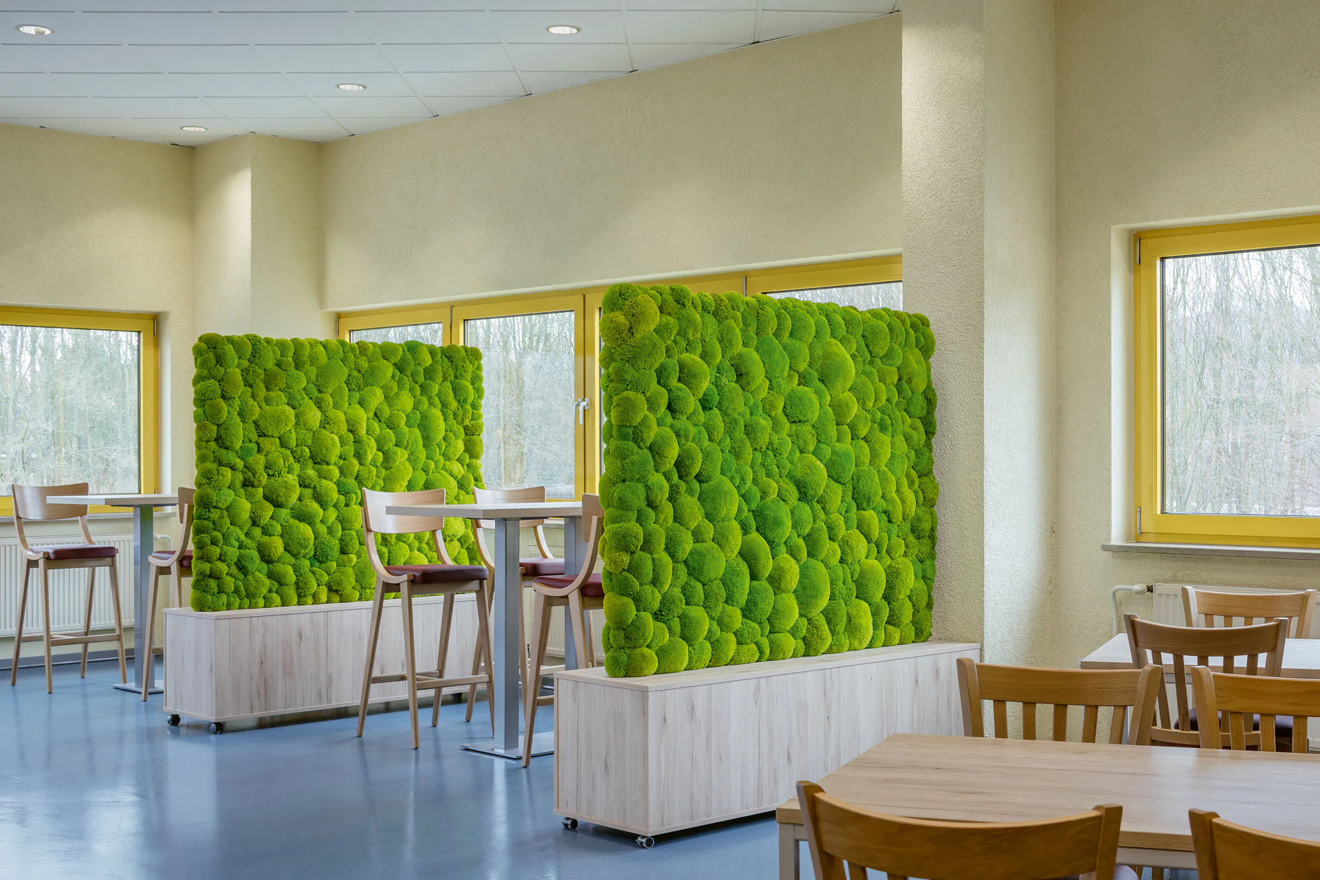 A green acoustic column made of moss in a modern office