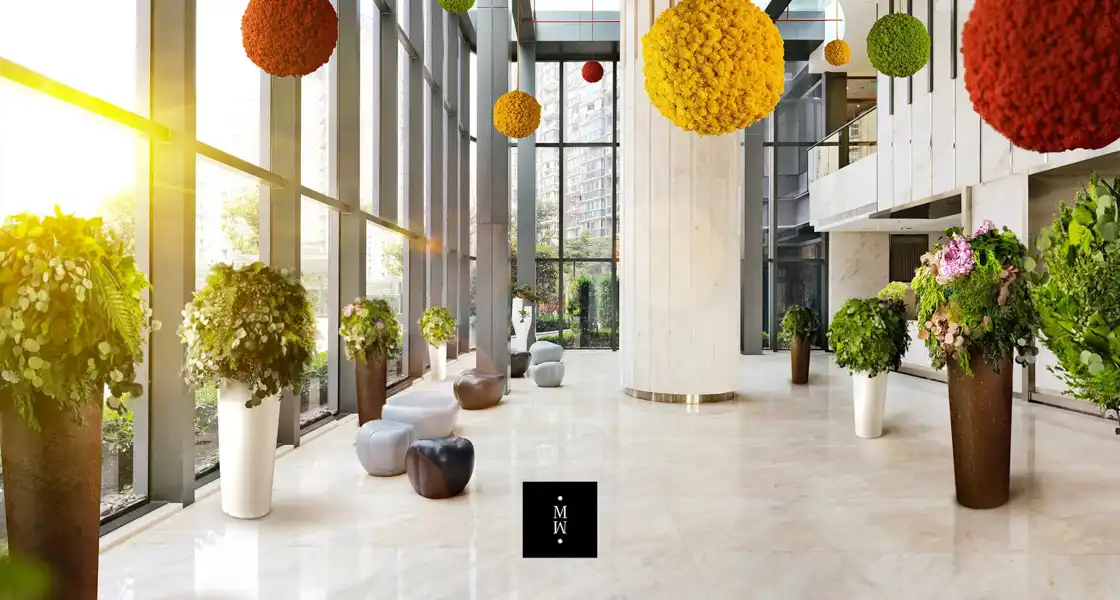 a large room with plants and a large window