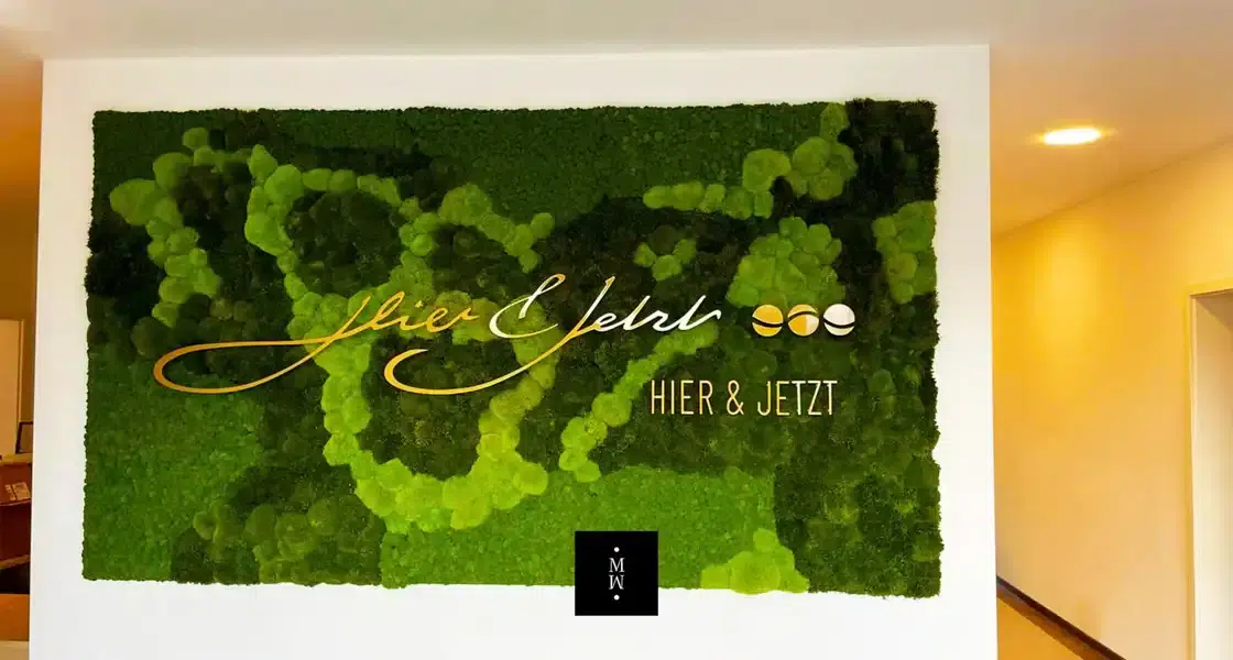 a green wall art with gold text