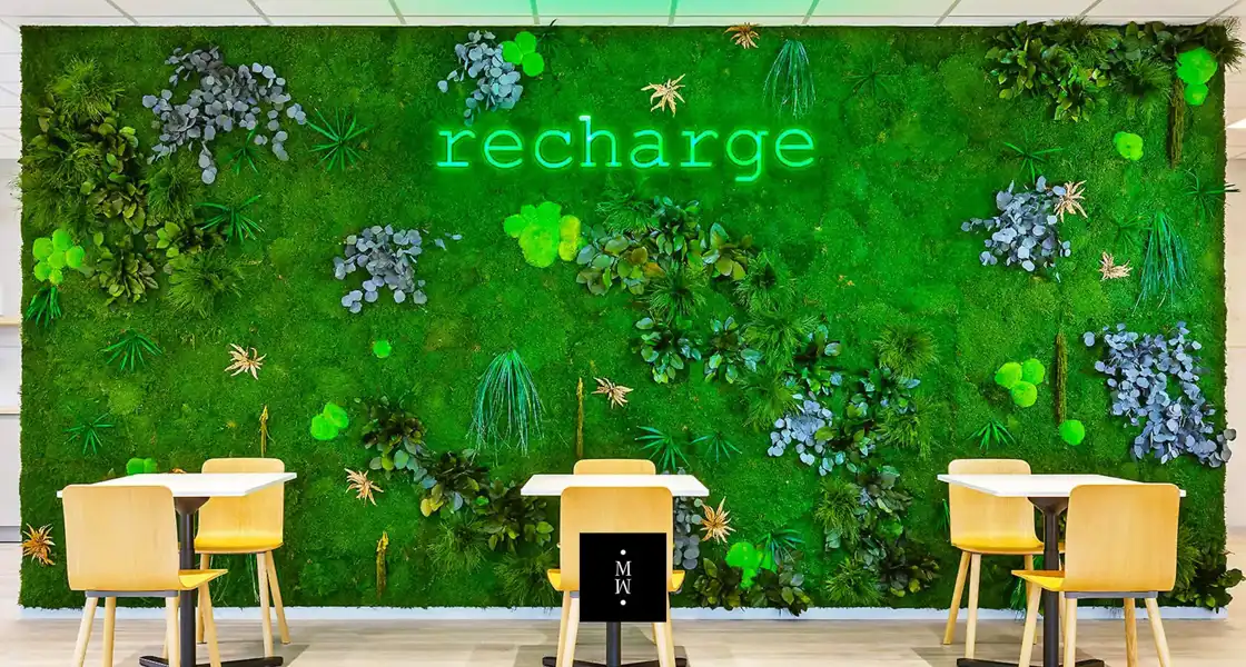 a green wall with plants and a sign