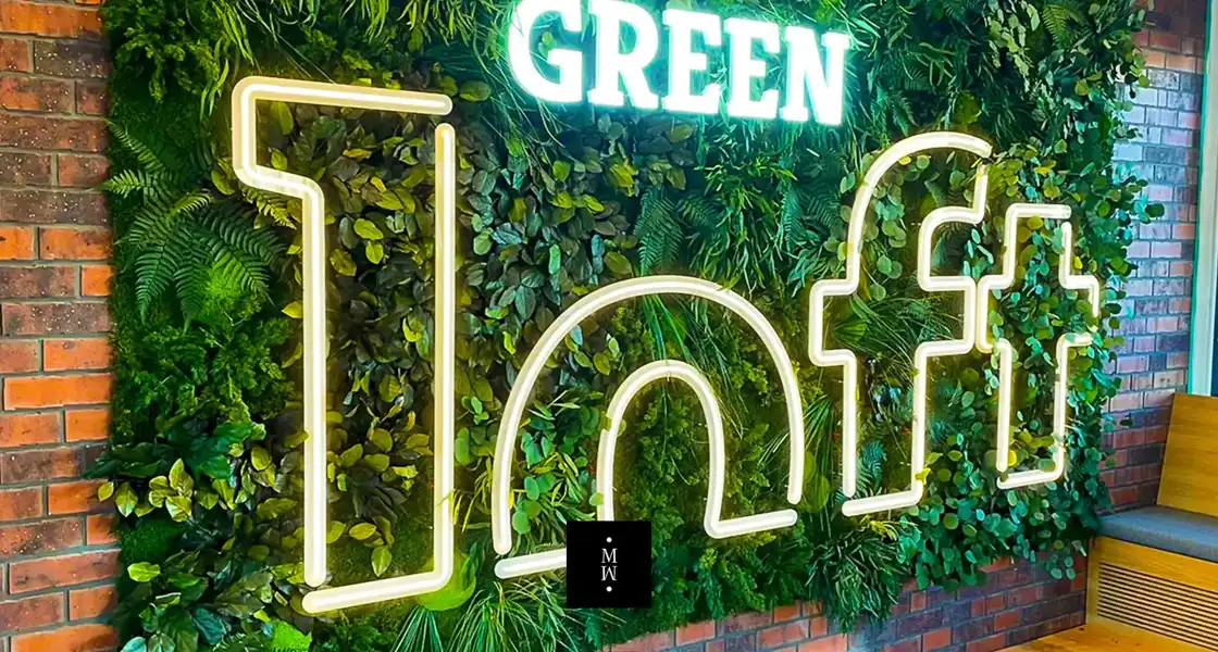 a sign on a wall with plants