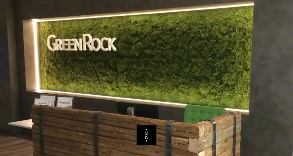 a sign with a green wall