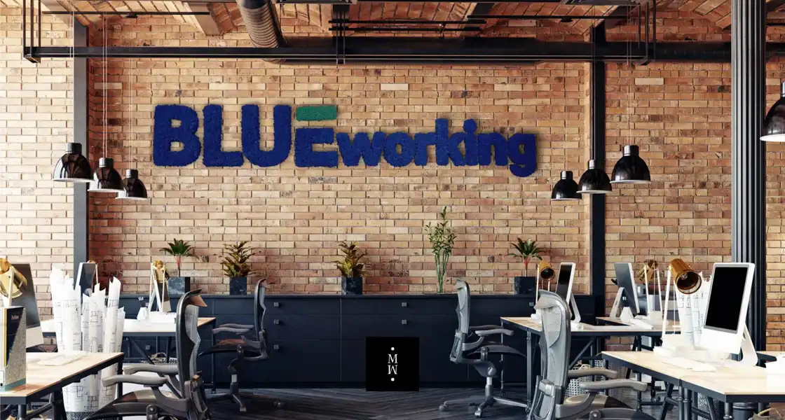 a room with a brick wall and a desk and chairs