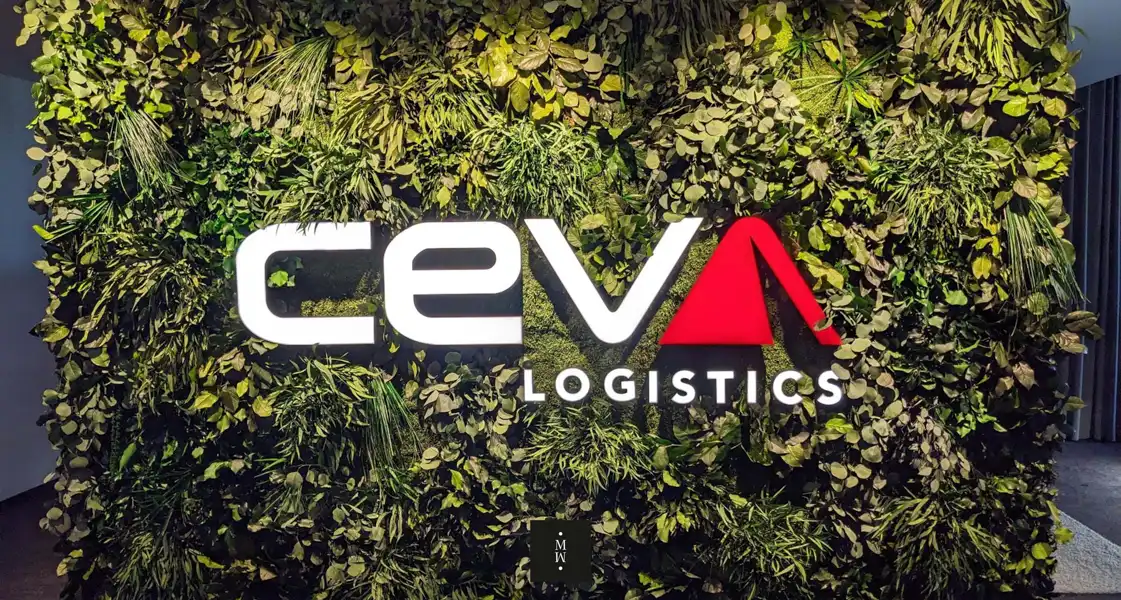 a sign on a wall of plants