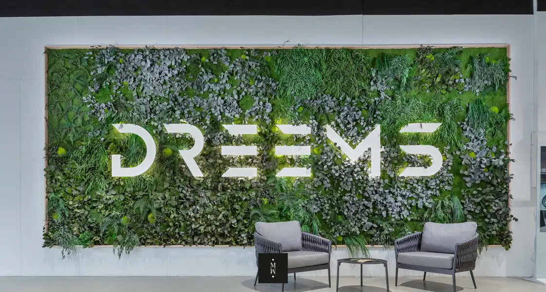 a wall with plants and a sign