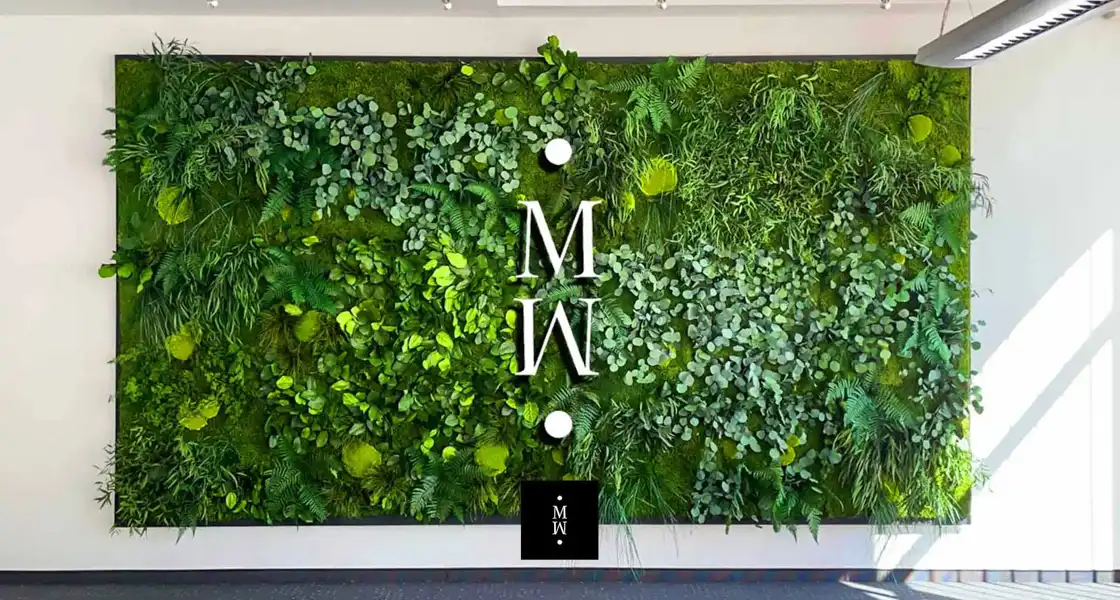 a wall with plants and letters on it