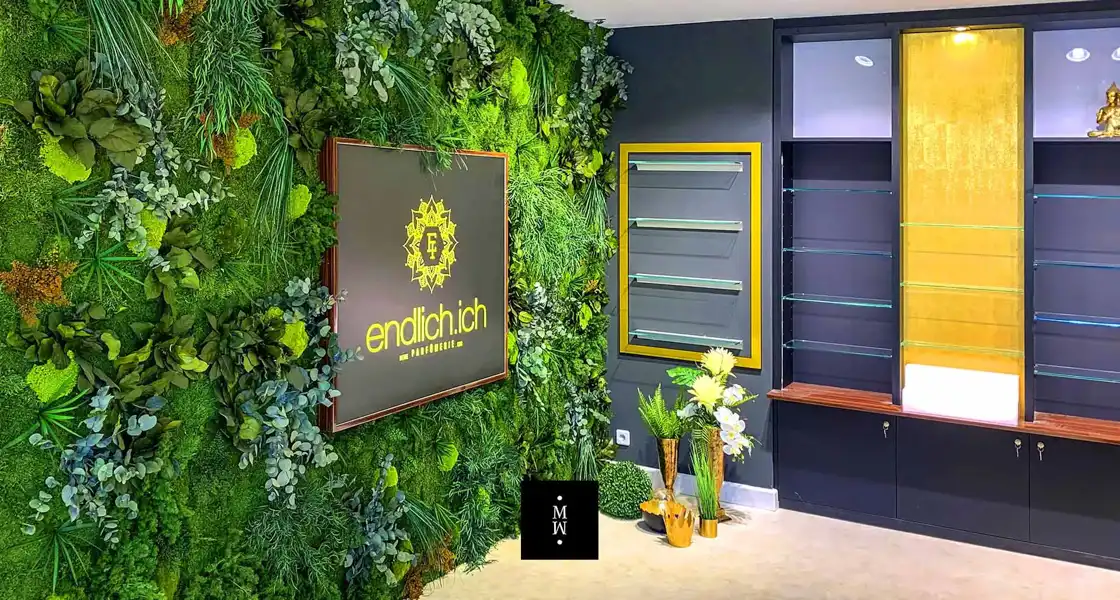 a green wall with plants and a sign