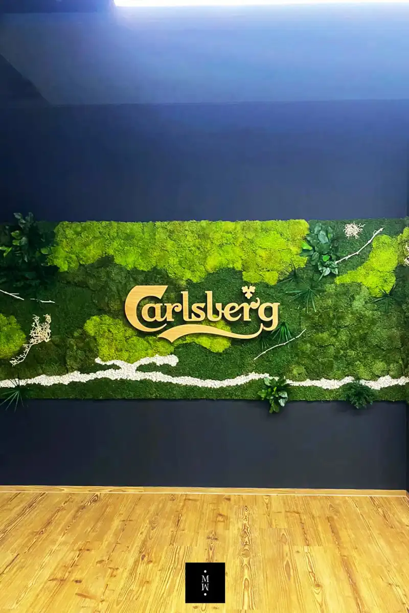 a green wall with plants and a sign