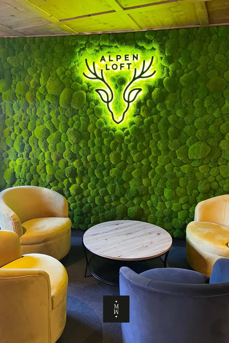 a green wall with chairs and a sign