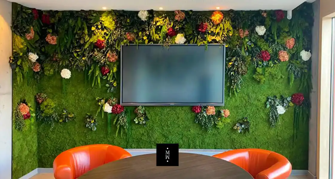 a tv on a wall with plants and flowers