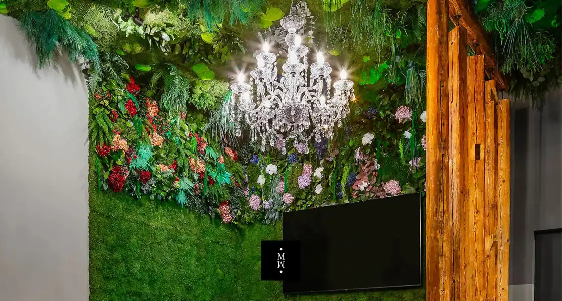 a chandelier in a room with plants and flowers