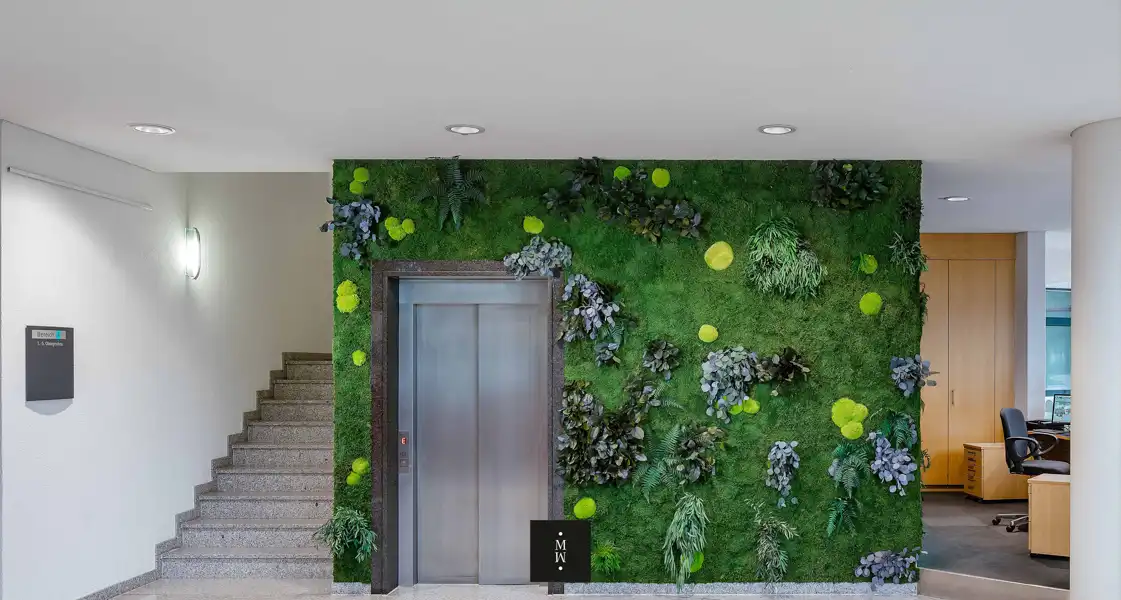 a wall with plants and a staircase