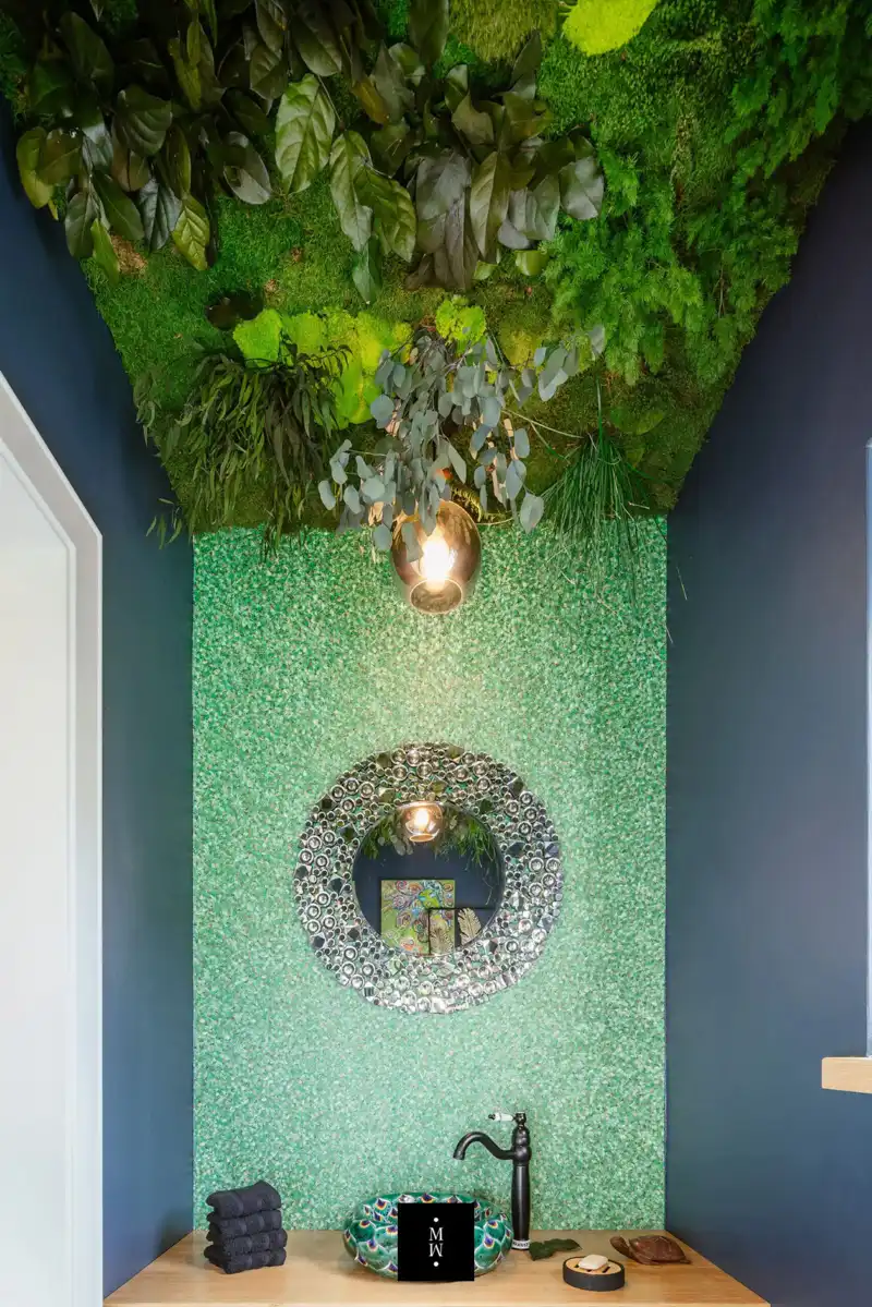 a green wall with plants and a mirror