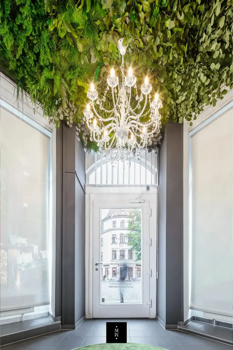 a chandelier from the ceiling of a room with plants