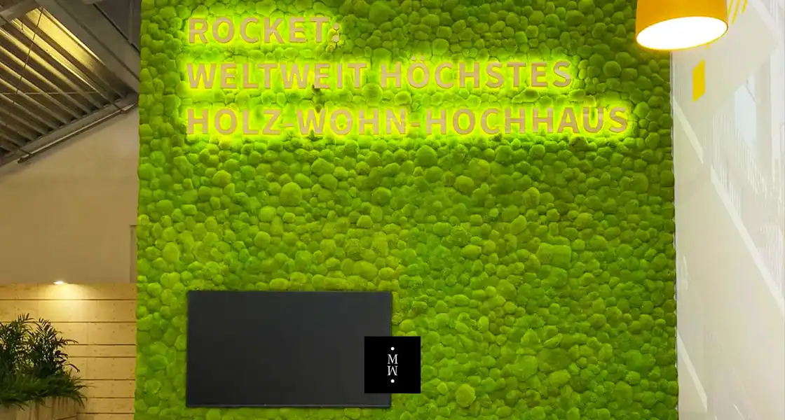 a green wall with a black laptop and a black rectangular object