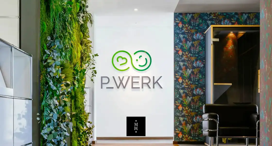 a wall with plants and a logo on it