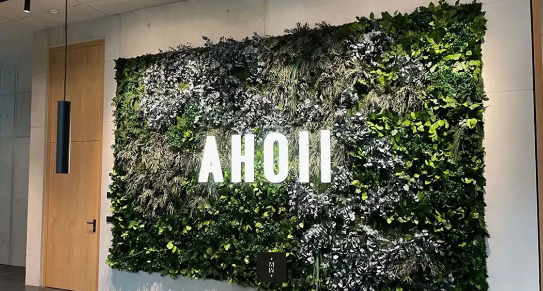 a wall with plants and a sign