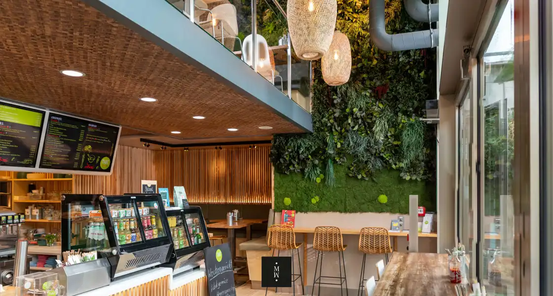 a restaurant with a green wall and plants