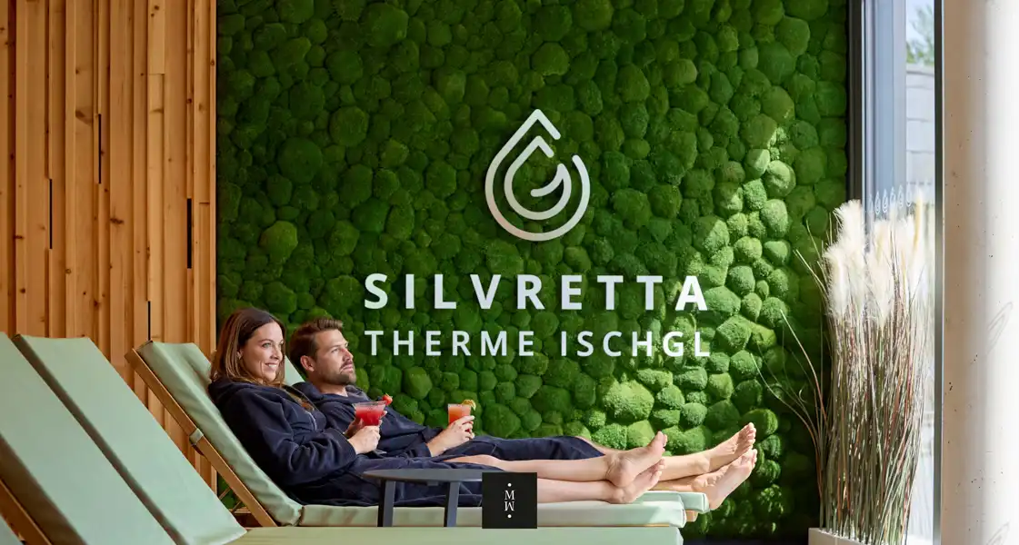 a man and woman sitting on lounge chairs