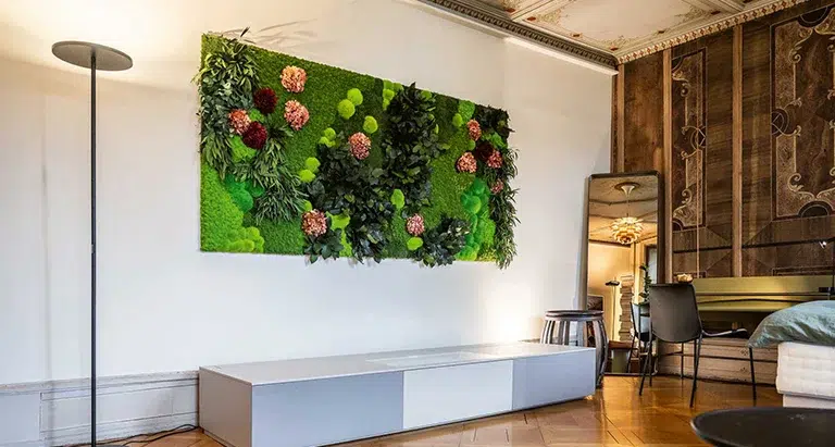 Bild aus Moos mit integrierten Blumen als kreative Wandgestaltung in einem Wohnraum von MoosMoos.