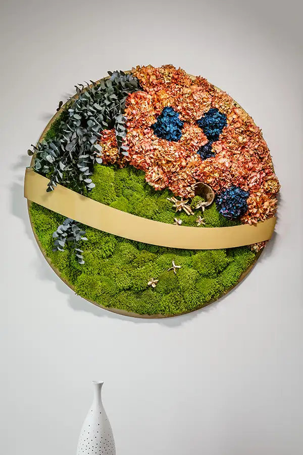 Rundes Bild aus Moos mit farbigen Blütenelementen und dekorativem Design – natürliche Wandkunst von MoosMoos.