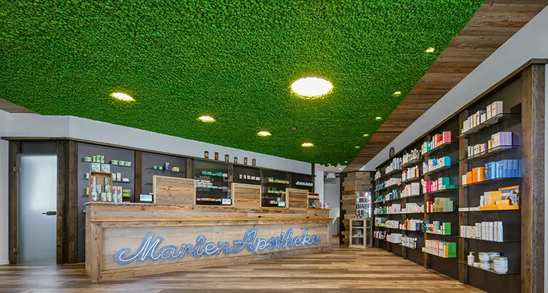 Apotheke mit auffälliger Decke aus Islandmoos von MoosMoos über dem Verkaufstresen, natürliches Design mit Wohlfühlatmosphäre