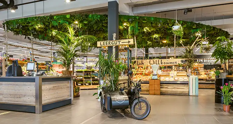 Supermarkt mit dekorativer Decke aus Moos von MoosMoos im Eingangsbereich für ein nachhaltiges Einkaufserlebnis