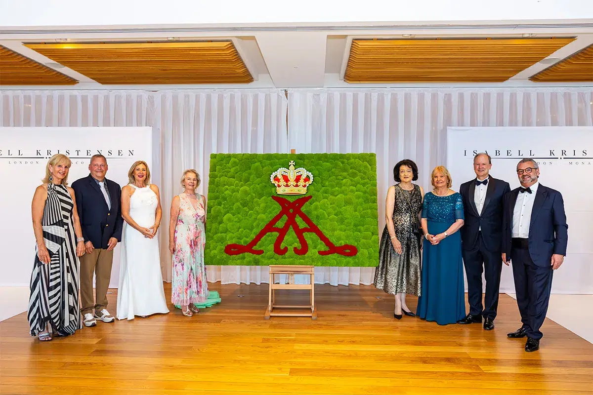 Gruppenfoto MOOSMOOS Monaco-Gala: Jens Loschke mit Vertretern des Club Allemand International und Isabell Kristensen vor dem königlichen Mooswappen