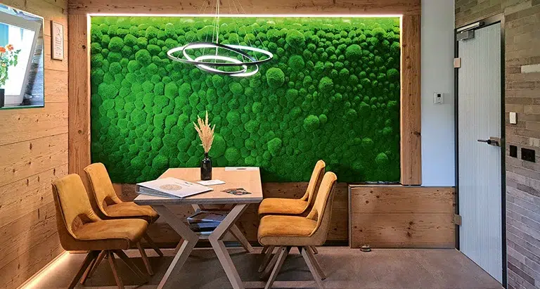 Besprechungsraum mit Holzelementen, Tisch und dekorativer Wand aus Ballenmoos von MoosMoos, nachhaltiges Raumdesign mit Naturakzenten