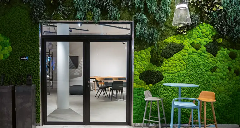 Moderner Eingangsbereich mit Glastür, Sitzmöbeln und kreativer Wand aus Moos von MoosMoos, nachhaltiges Naturdesign für Büro- und Meetingräume