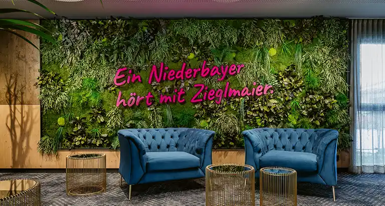 Große grüne Wand aus Moos von MoosMoos mit Schriftzug „Ein Niederbayer hört mit Zieglmaier“.