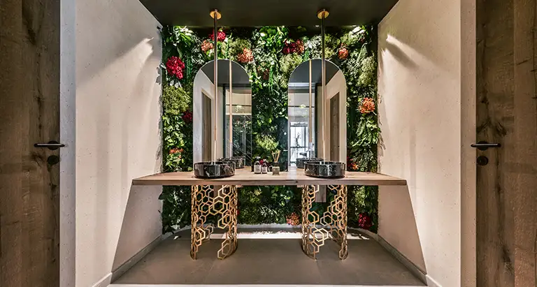 Stilvolles Badezimmer mit Doppelwaschtisch, Spiegeln und dekorativer Wand aus Moos mit Pflanzen und Blumen von MoosMoos, nachhaltiges Naturdesign für moderne Bäder