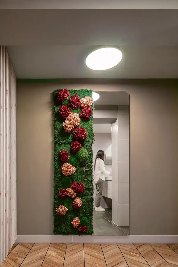 Moderner Eingangsbereich mit schmaler Wand aus Moos mit Pflanzen und Blumen und Spiegel – platzsparendes MoosMoos Design für stilvolle Räume.