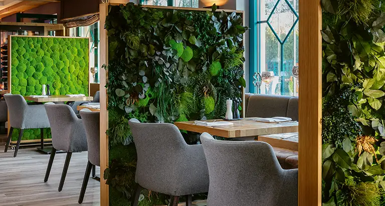 Eleganter Raumteiler von MoosMoos mit Wand aus Moos und Pflanzen im Restaurant