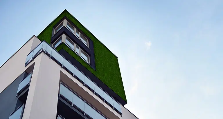 Moderne Hochhausfassade mit Greenovation Mooswand – nachhaltige Waldmoos-Fassadengestaltung in der Stadt