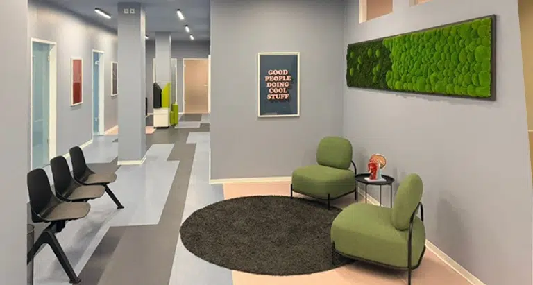 Moosbild in modernem Wartebereich mit Sitzmöbeln und rundem Teppich